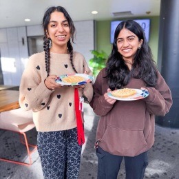 two girls holding food and smiling