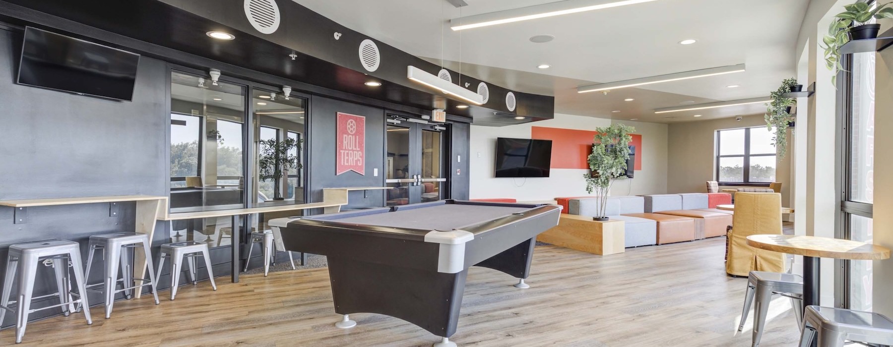 a clubroom with a pool table, tables and chairs