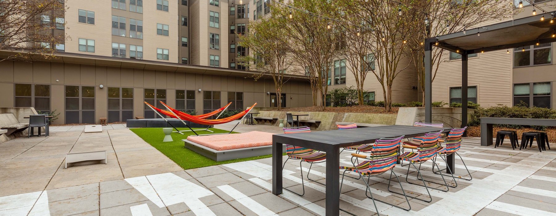 a courtyard with hammocks, tables and chairs
